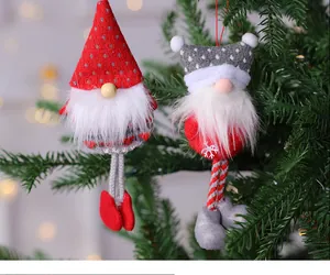 Vista detallada de adornos de gnomos navideños de felpa colgados en un gran abeto.