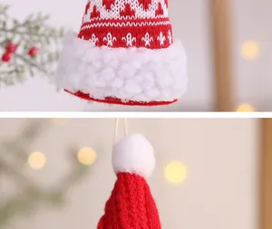 Detailansicht eines handgefertigten rot-weißen gestrickten Mini-Weihnachtsmützen-Anhängers