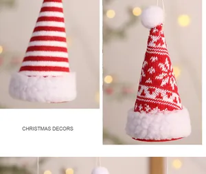 Nahaufnahme von rot-weißen gestrickten Mini-Weihnachtsmützen als Baumschmuck Dekor