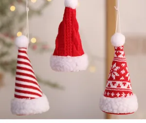 Set aus drei Mini-Strick-Weihnachtsmützen als festliche Dekoration für den Baum.