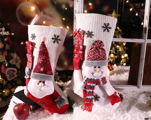 Detailweergave van gebreide kerstsokken met 3D-figuren van de Kerstman en een sneeuwpop