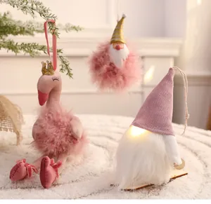 Nahaufnahme eines rosa Gnoms mit LED-Licht und Flamingo-Plüsch-Weihnachtsanhängern.