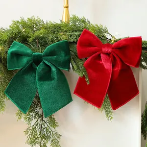 Festive red and green velvet Christmas bow ornaments on a pine garland background.