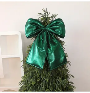 Detail of a large metallic green bow used as a Christmas tree topper decoration