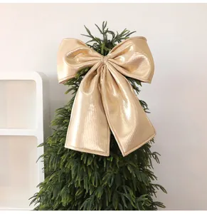 Large gold metallic bow Christmas tree topper decoration with shiny textured finish