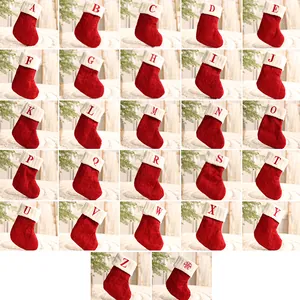 Sammlung roter gestrickter Weihnachtssocken mit weißen Bündchen und bestickten Buchstaben A-Z.