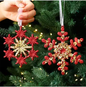 Close-up of red glitter snowflake ornaments with gold sequins for Christmas tree.