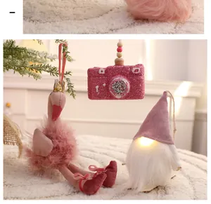 Detailansicht von rosa Weihnachtsschmuck inklusive Flamingo und leuchtendem Wichtel.