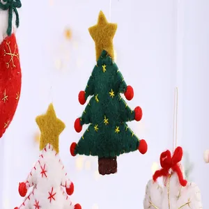 Detail macro view of handcrafted felt Christmas tree ornament with red pom-pom accents