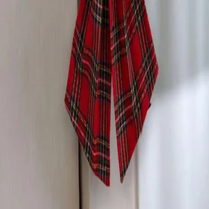 Detailed view of a large red plaid Christmas tree bow ornament with traditional pattern