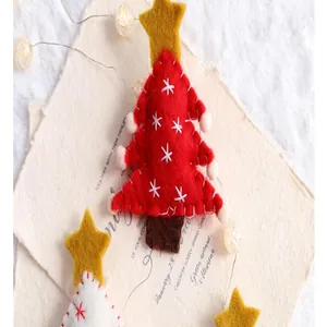 Close-up of a handmade red felt Christmas tree ornament with gold star and embroidery details