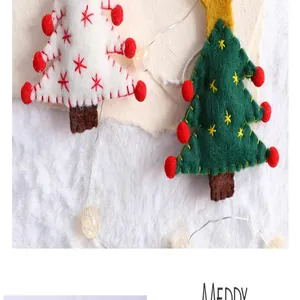 Macro view showing detailed stitching on white and green felt Christmas tree ornaments.