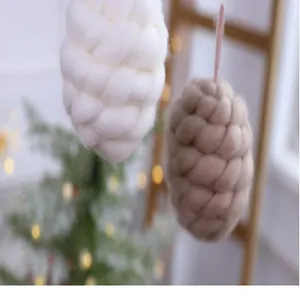 Close-up of handcrafted white and brown wool pinecone ornaments for Christmas tree decor.