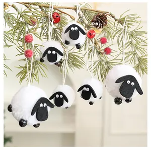 Detailweergave van wollige schaapornamenten van vilt hangend aan een feestelijke dennentak