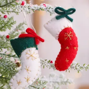 Pair of miniature felt Christmas stocking ornaments with gold snowflake embroidery