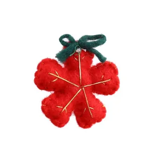 Red felt snowflake ornament with green bow for festive Christmas tree decoration