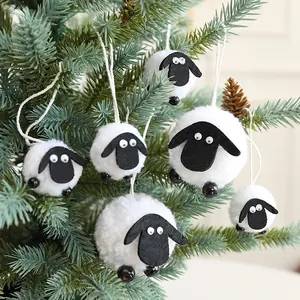 Handgemaakte schapenornamenten van wolvilt hangend aan een boom voor kerstdecoratie
