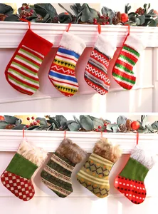Detailed view of various festive knit Christmas stockings with faux fur cuffs hanging on a mantel.