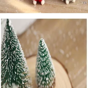 Close-up van mini groene vilten kerstbomen met witte kunstsneeuw op houten basis