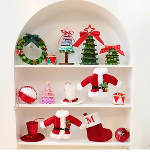 Collectie pluchen DIY-kerstversieringen gepresenteerd op witte planken