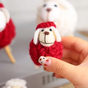 Handgemaakt rood schaap van wolvilt voor creatieve kerstdecoratie op het bureau
