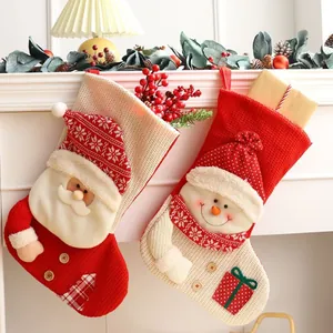 Pair of knitted Christmas stockings featuring plush Santa Claus and Snowman characters