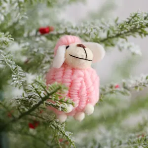 Schattig roze vilt schaap kerstornament op besneeuwde tak voor feestelijke DIY-decoratie
