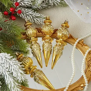 Detail view of golden conical Christmas ornaments with pearls on a mirror background