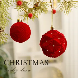 Elegant red flocked Christmas tree ornaments with textured pattern hanging on pine branch