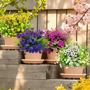 Fiori artificiali colorati di gipsofila in vasi di terracotta su scale da giardino