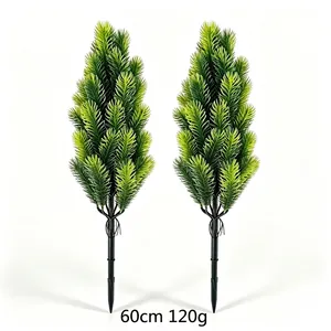 Detail view of two artificial green pine needle stakes for outdoor Christmas decor