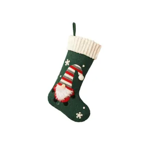 Green velvet Christmas stocking with festive gnome embroidery and white snowflakes