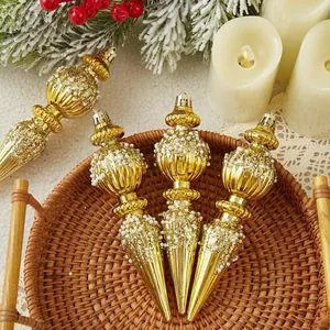 Close-up of elegant gold tapered Christmas ornaments with glitter and pearls in a basket