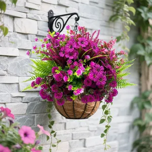 Vivaci fiori artificiali viola in un cesto appeso contro un muro di pietra.