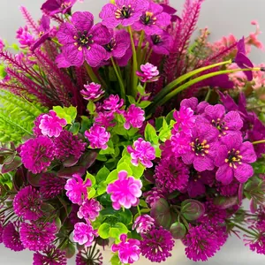 Dettaglio di fiori artificiali viola vibranti e fogliame verde per decorazione giardino.