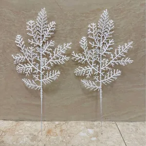 Primer plano de dos ramas de pino artificiales blancas para decoración navideña.