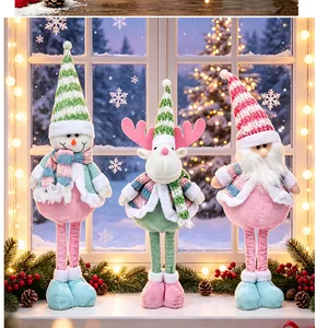 Detailed view of pastel Christmas plush dolls with telescopic legs on a window sill