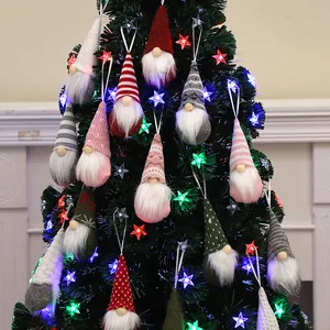 Handmade Christmas gnome ornaments set with colorful knitted hats on a festive tree.