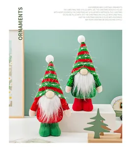 Detailed close-up of two sequined Christmas gnomes in festive red and green outfits.
