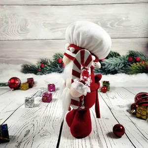 Detailansicht einer plüschigen Koch-Gnom-Weihnachtspuppe mit einer roten Zuckerstange