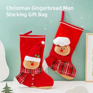 Festliche rote Weihnachtssocken mit süßen Lebkuchenmännchen-Charakteren in Winteroutfits