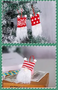 Knitted Christmas gnome ornaments hanging on a snowy tree and styled on vintage props.