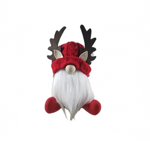 Gnome de Noël en peluche avec bois de renne et bonnet en tricot rouge pour la fête.