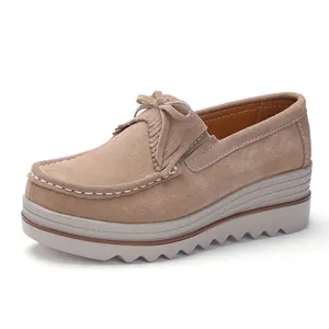 Stijlvolle beige suède damesloafers met sleehak, plateau en strik met franjes detail