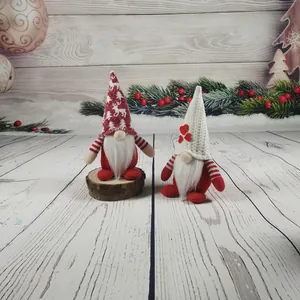 Zwei gestrickte Weihnachtswichtel mit weißen Bärten in einer festlichen Winterszene