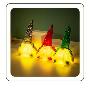 Détail de trois gnomes de Noël à paillettes brillant d'une lumière LED dorée chaude