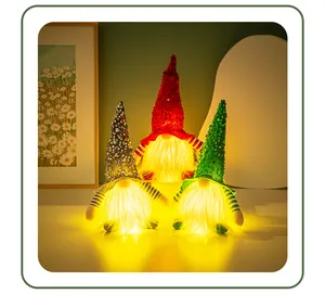 Vue détaillée de trois gnomes de Noël à paillettes avec lumières LED chaudes