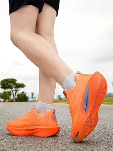 Vue latérale de chaussures de course légères orange vif portées pendant l'entraînement