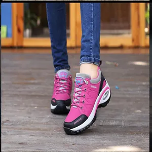 Close-up detail of women's pink and black outdoor hiking shoes worn on a wooden deck