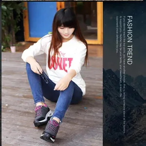 Detail of durable grey trekking shoes with pink laces worn by a model in outdoor setting